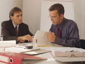 2 Männer im Büro lesen Unterlagen