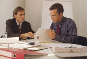 2 Männer im Büro lesen Unterlagen