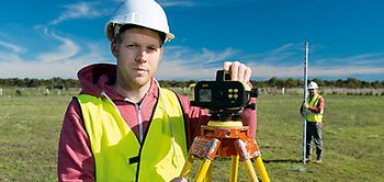 2 Personen vermessen ein Grundstück_GettyImages_Peter M. Fisher