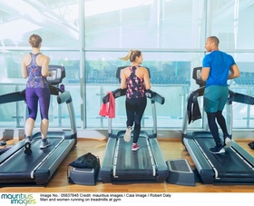 Man and women running on treadmills at gym