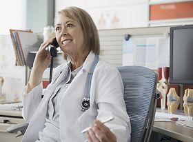 Ältere Ärztin beim Telefonieren