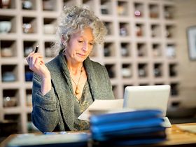 ältere Dame arbeitet an Schreibtisch im Büro