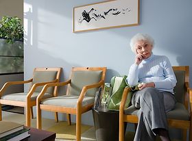 Ältere Dame sitzt im Wartezimmer
