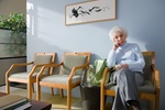Ältere Dame sitzt im Wartezimmer