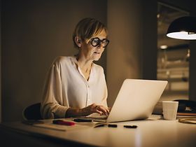 ältere Frau arbeitet im HomeOffice spät