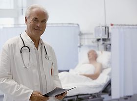 Älterer Arzt mit Patient im Hintergrund