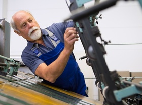 Älterer Mann an Maschine in der Produktion