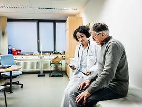 älterer Mann redet mit Ärztin