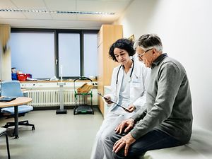älterer Mann redet mit Ärztin