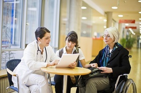 Ärztin in Gespräch mit einer älteren und einer jüngeren Frau