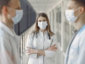 Ärztin in weißem Kittel und mit Maske