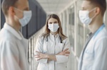 Ärztin in weißem Kittel und mit Maske