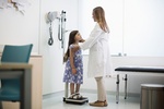 Ärztin wiegt junges Mädchen