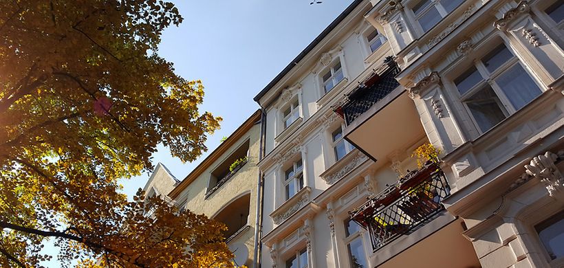 Altbau Mehrfamilienhaus mit Bäumen und Himmel