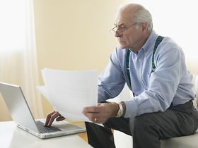 Mann alt Senior Laptop Wohnung Briefe