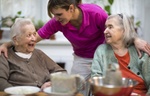 Altenpflegerin unterhält sich mit zwei älteren Frauen