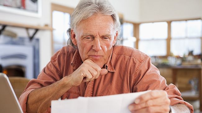 Alter Mann am Laptop der sich etwas durchliest