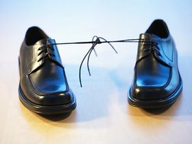 An den Schnürsenkeln zusammengebundene Schuhe