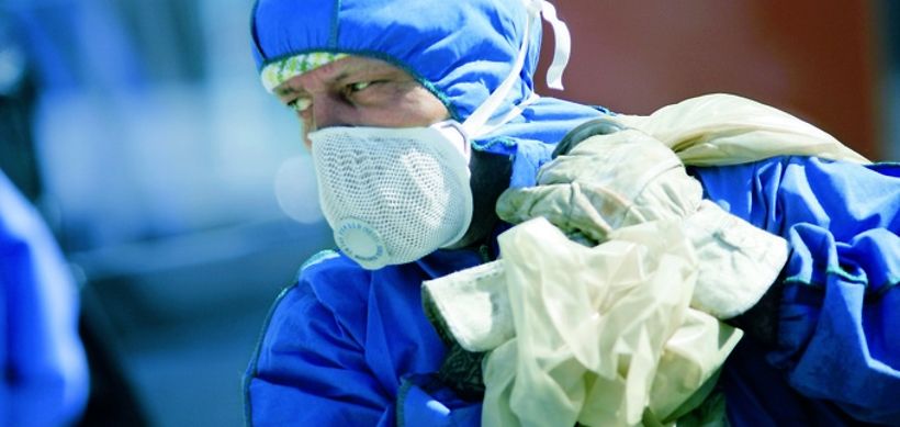 Arbeiter mit Schutzkleidung und Müllsack