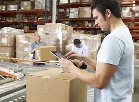 Arbeiter scannt Paket auf dem Fließband