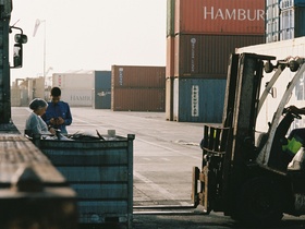 Arbeiter zwischen Containern