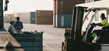 Arbeiter zwischen Containern