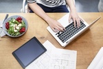 Arbeitsplatz mit Laptop, Tablet und gesundem Salat