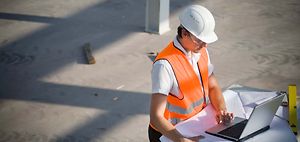 Arbeitsschutz_Mann in Warnweste und Helm