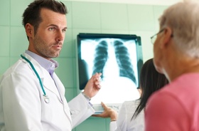 Arzt bespricht Röntgenbild mit Patienten