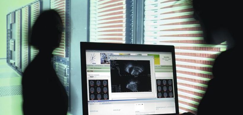 Arzt sieht an Monitor medizinische Daten an, Netzwerk fuer Medizi