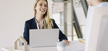 Baufinanzierung Finanzierung Frauen Büro Laptop Wohneigentum