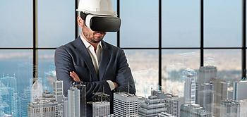 Bauingenieur mit VR-Brille guckt auf Hochhausmodelle