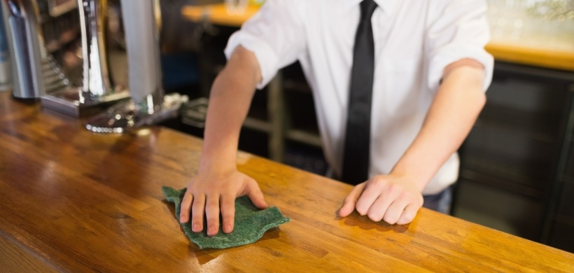 Bedienung in Kneipe wischt Bar