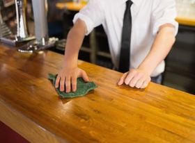 Bedienung in Kneipe wischt Bar