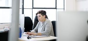 Businesswoman using computer at desk. Confident female profession