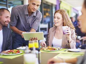 Besprechung unter Kollegen bei Mittagessen in Kantine