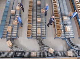 Blick von oben auf Fließband im Versandhandel mit Paketen