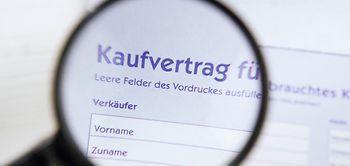 Blick durch Lupe auf Kaufvertrag