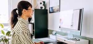 blick ueber schulter auf monitor mit finanzsoftware