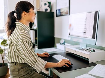blick ueber schulter auf monitor mit finanzsoftware