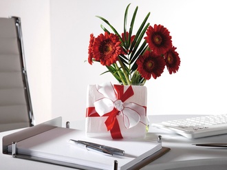 Blumenstrauss und Geschenkpaeckchen auf Schreibtisch