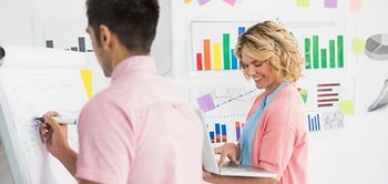 Brainstorming zweier Kollegen mit Flipchart Laptop und Diagrammen