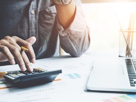 Close up a man working about financial with calculator at his office to calculate expenses, Accounti