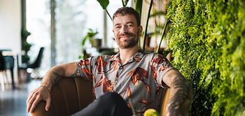 Büro Mann buntes Hemd Tattoos Dschungel 