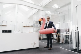 Büro weiß modern Mann Anzug Schwimmring Flamingo rosa