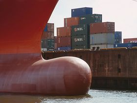 Bug eines Containerschiffs, gestapelte Container am Kai