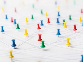 Bunte Pinnadeln mit Faeden verbunden