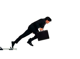 Business-Mann mit Koffer an Sprint-Startblöcken