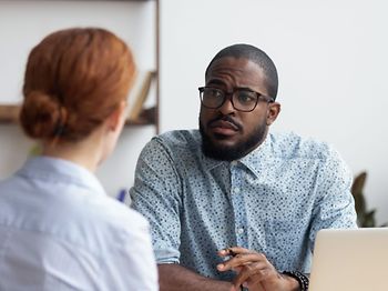 Chef hört Mitarbeiterin zu