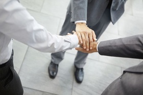 Closeup of group of business people with hands together